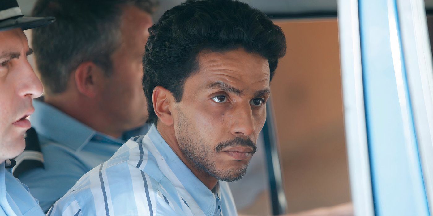 Sami Bouajila looks on while sitting in a car with other men