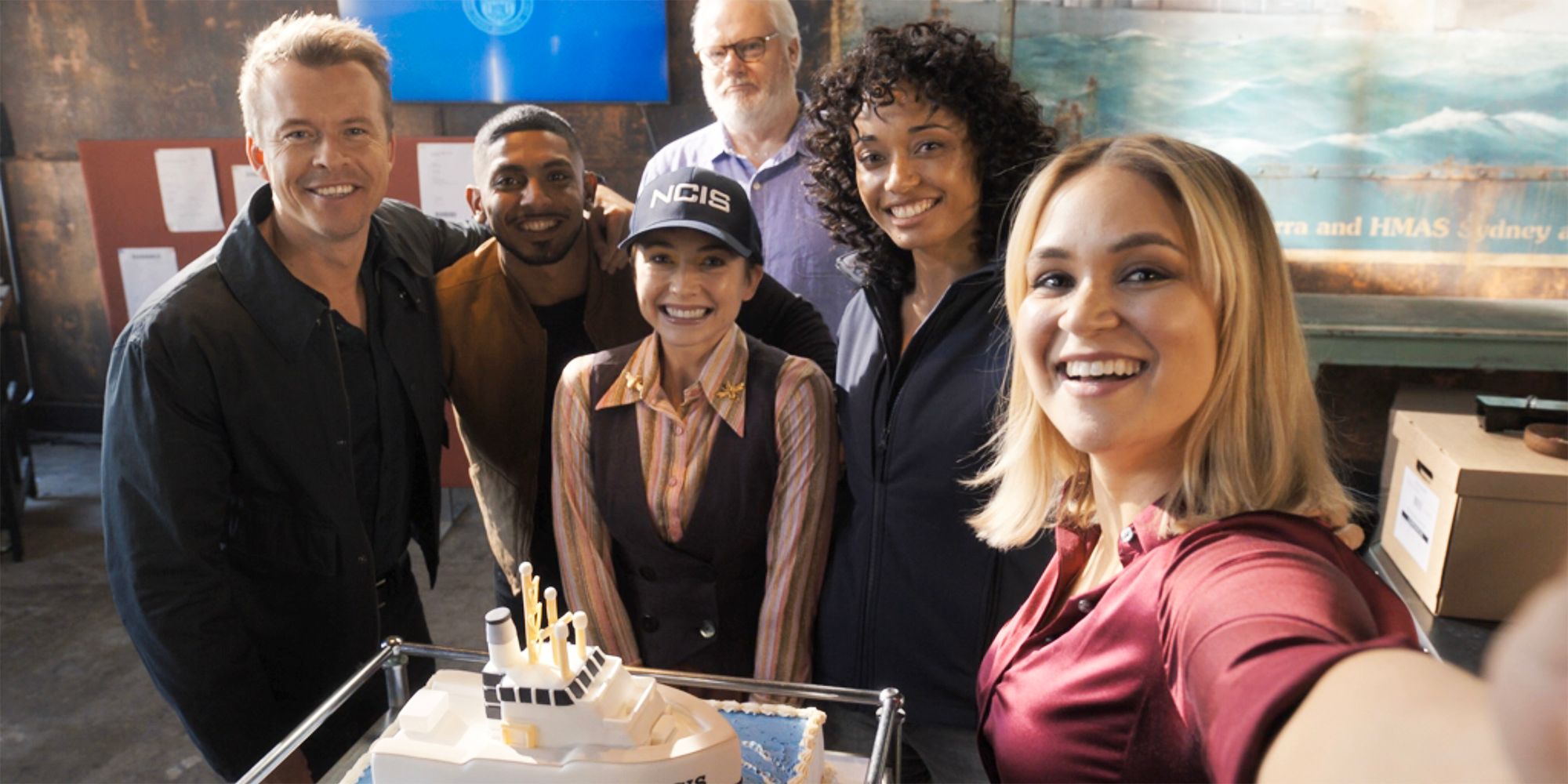 The team posing for a selfie with a cake in NCIS Sydney