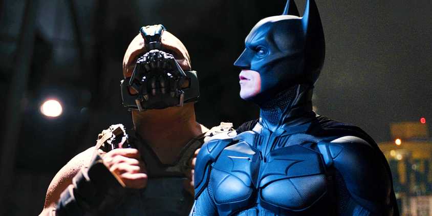Tom Hardy As Bane In The Shadows With Christian Bale As Batman Looking To The Side In Costume In The Dark Knight Rises