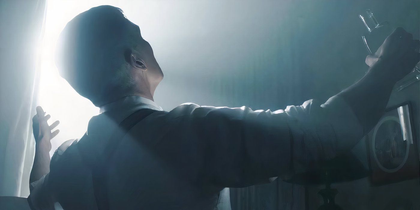 Tommy Shelby with open arms as daylight enters a dark room through a gap in the curtains in Peaky Blinders season 4