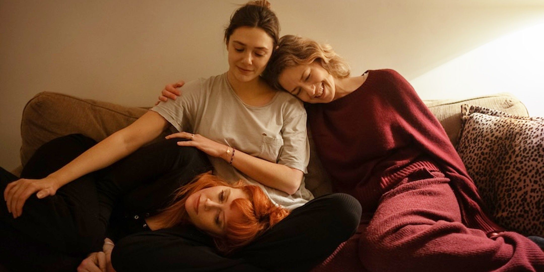 Elizabeth Olsen, Carrie Coon, and Natasha Lyonne sitting on the couch in His Three Daughters