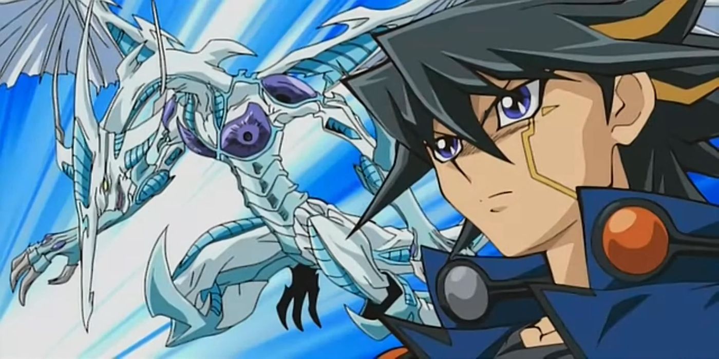 Yusei Fudo de Yu-Gi-Oh! 5Ds está de pé ao lado, com um olhar intenso no rosto. Um monstro de uma de suas cartas, Stardust Dragon, está de pé ao lado dele.