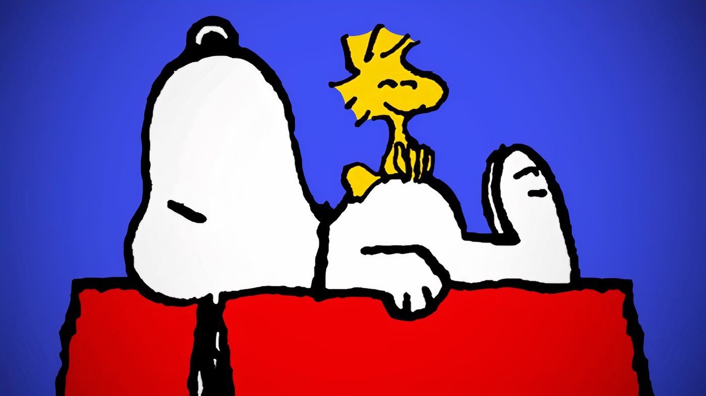 Snoopy lying on top of his dog house with Woodstock on his stomach.
