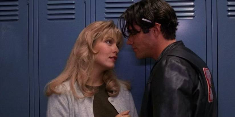Laura Palmer and Bobby Briggs in Twin Peaks: Fire Walk With Me. They're by the high school lockers. Laura looks into Bobby's eyes. Bobby has a cigarette behind his ear.