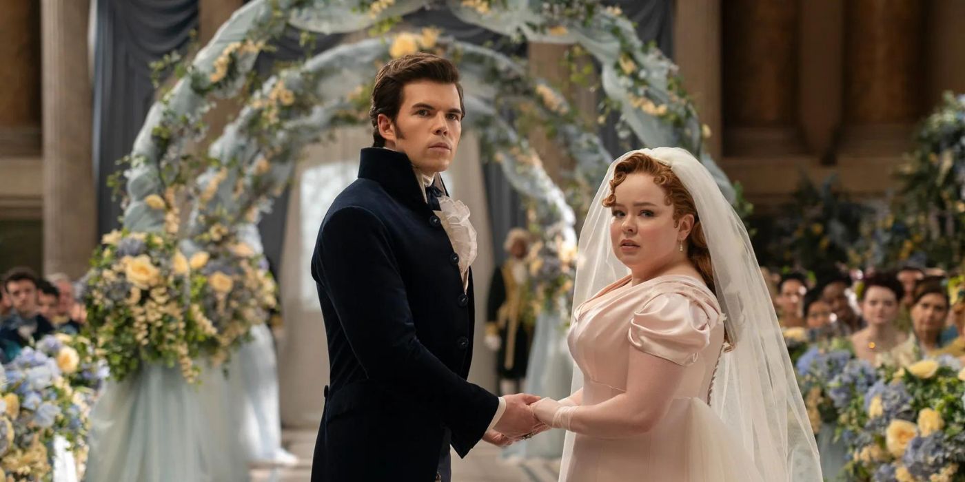 Colin Bridgerton and Penelope Featherington on their wedding day, they are looking at something off camera.