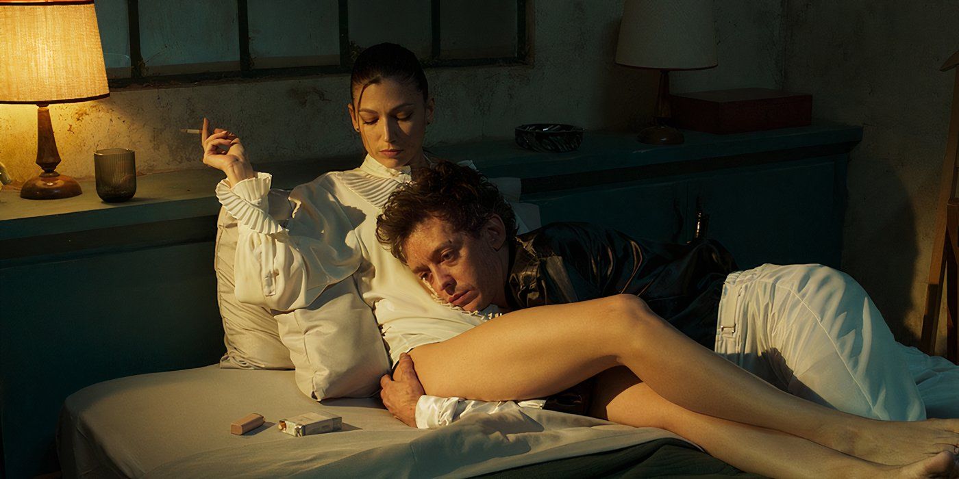 A man holds a woman smoking in bed in Kill the Jockey still