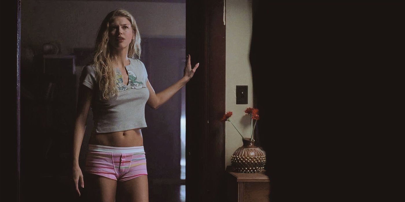 Adrianne Palicki como Jessica Moore na primeira temporada de Supernatural, de cueca boxer e camiseta, parada no batente de uma porta.