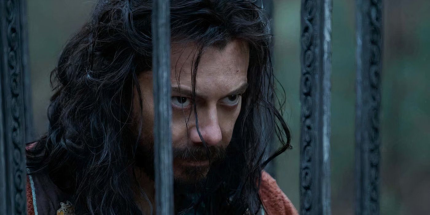 Alvaro Morte looks serious in a cage in The Wheel Of Time