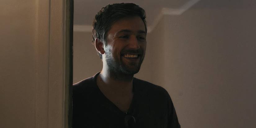Brandon Sklenar smiles while standing in the doorway in Indigo Valley