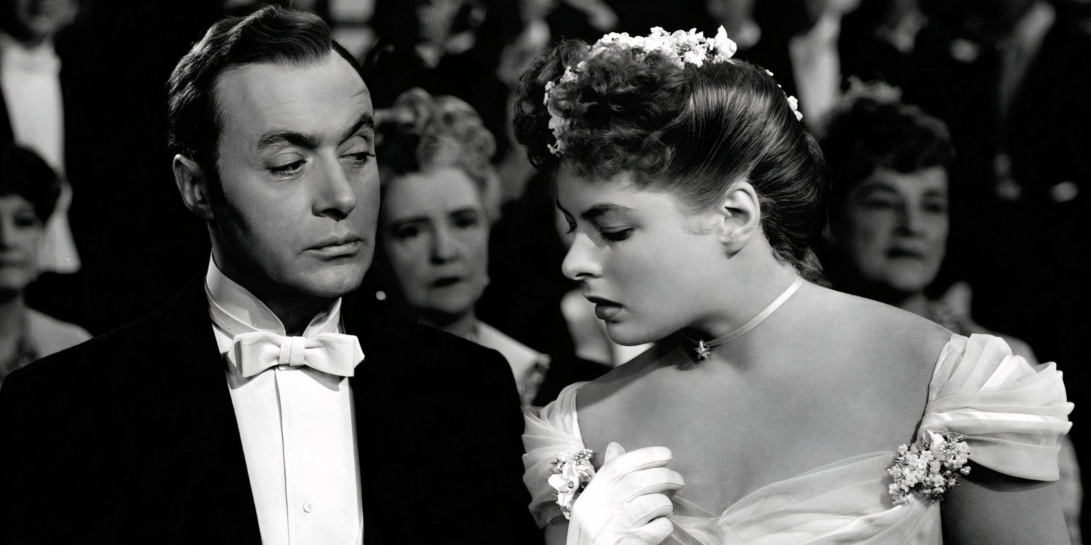 Ingrid Bergman olha para o relógio nas mãos de Charles Boyer. 