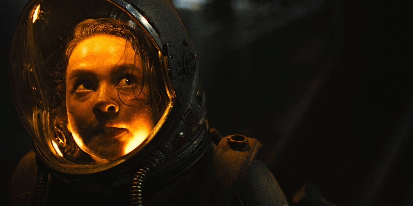 Primer plano de Cailee Spaeney como Rain con un casco espacial iluminado por una luz amarilla en Alien Romulus