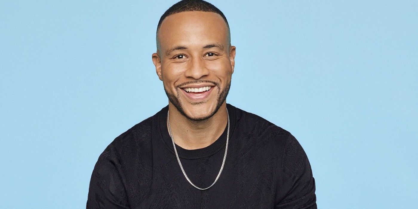 DeVon Franklin from Married At First Sight smiling in a black sweater in front of a blue background.