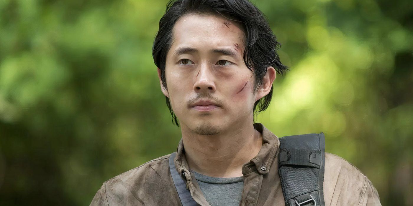 Steven Yeun as Glenn Rhee walking outdoors with cuts on his face in The Walking Dead