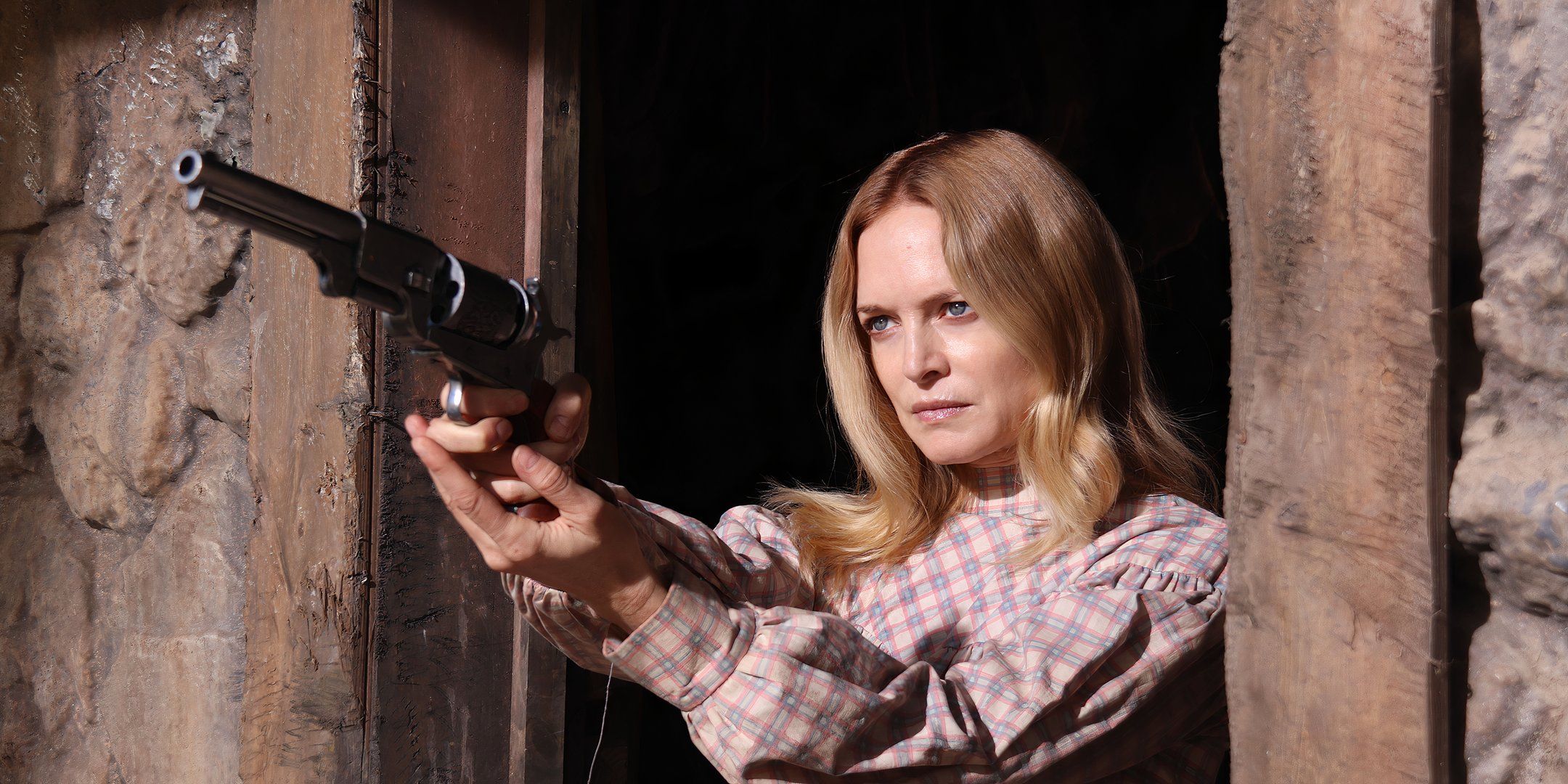 Heather Graham as Pandora aims her gun while standing in her doorway in Place of Bones