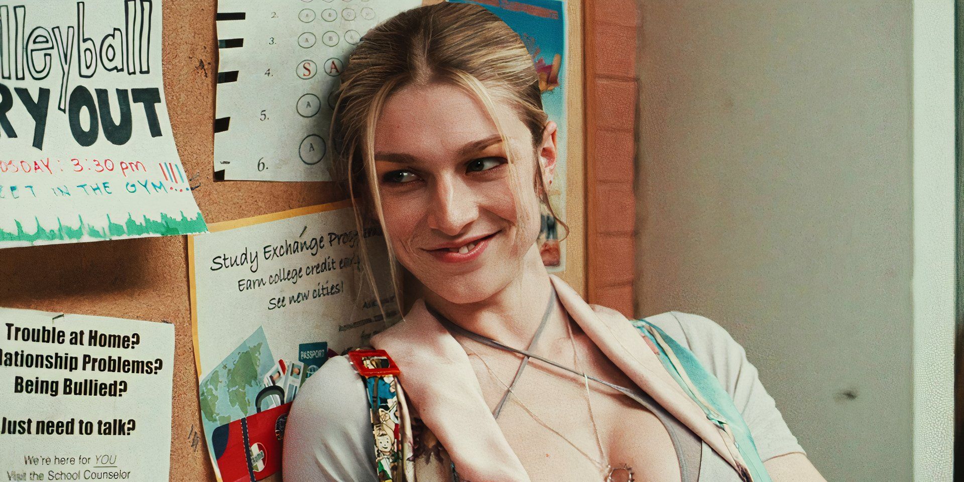 Hunter Schafer sorrindo e encostado na parede como Jules em Euphoria