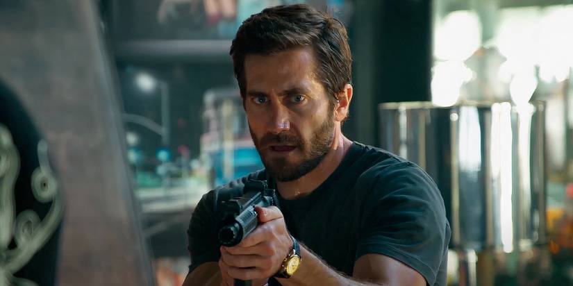 Jake Gyllenhaal as Danny Sharp pointing a gun in Ambulance
