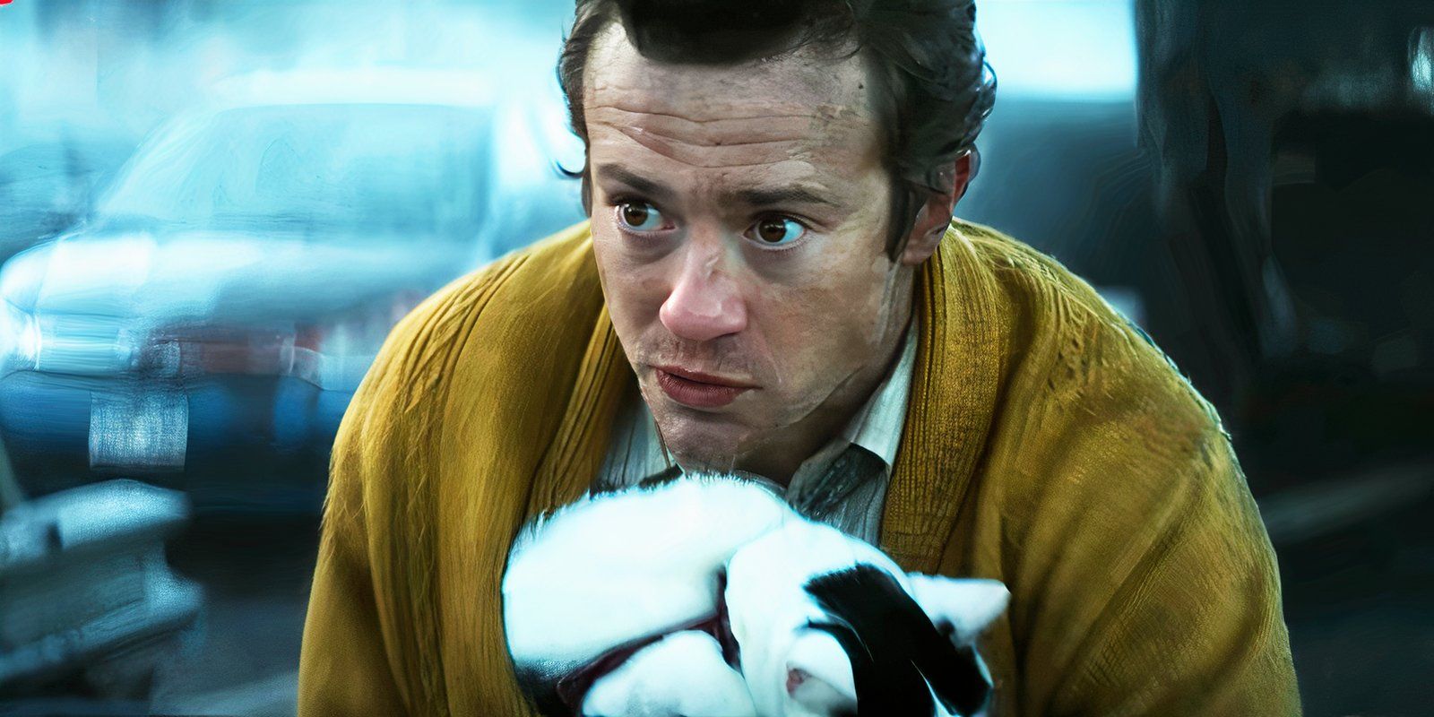 Eric (Joseph Quinn) holding Frodo the cat and wearing Sam's yellow cardigan in A Quiet Place Day One