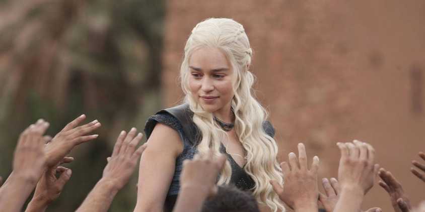 Daenerys Targaryen (Emilia Clarke) in a crowd of raised hands in Game of Thrones season 3, episode 10, 