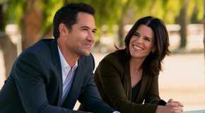 Manuel Garcia-Rulfo as Mickey and Neve Campbell as Maggie smiling in The Lincoln Lawyer