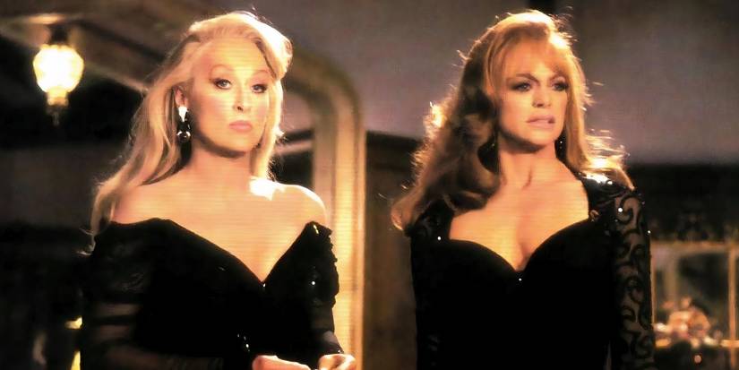 Meryl Streep as Madeline Ashton and Goldie Hawn as Helen Sharp stood together, glammed up, and wearing black dresses in Death Becomes Her.