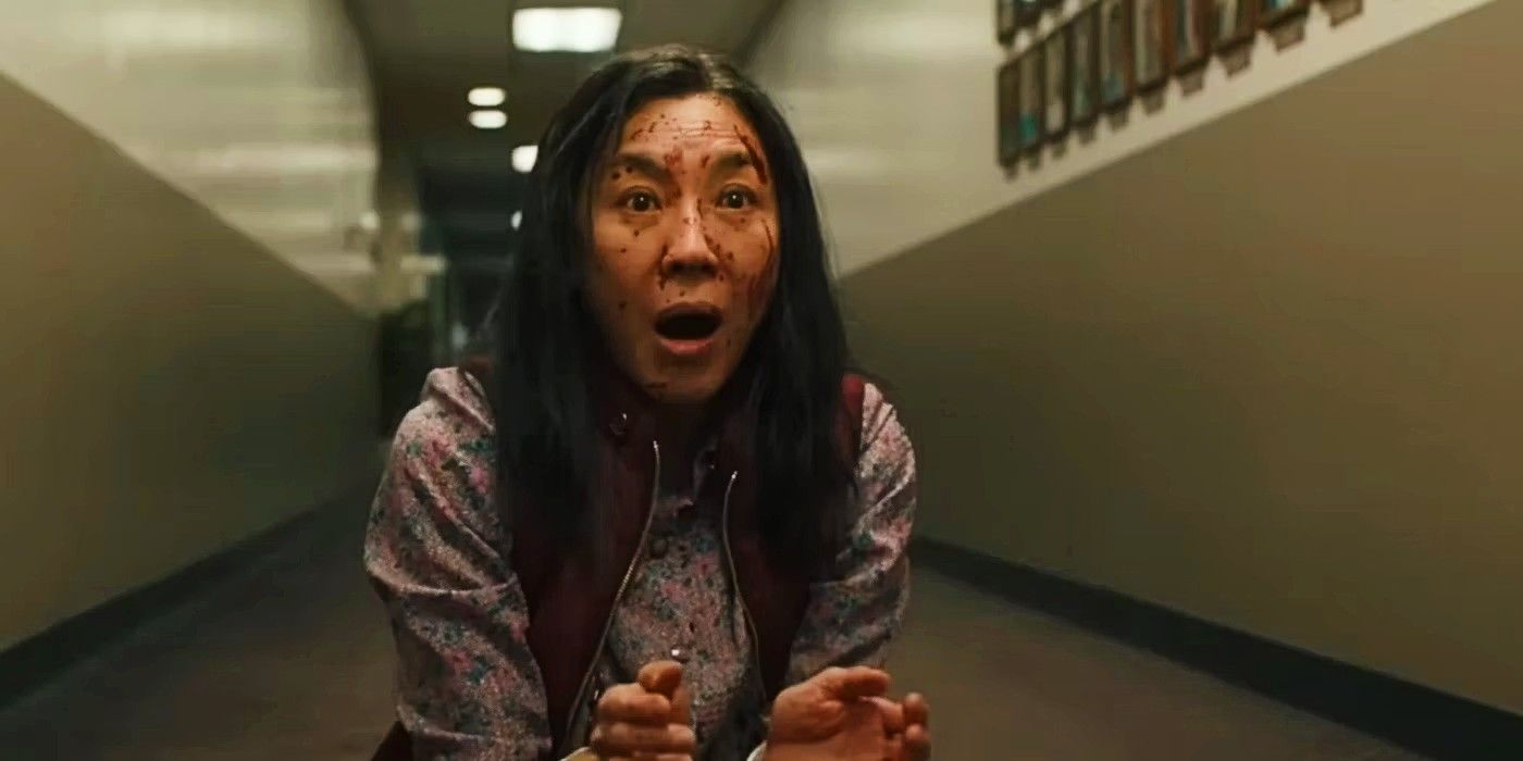 Evelyn Wang (Michelle Yeoh) looks shocked while her face is covered with blood in Everything Everywhere All at Once