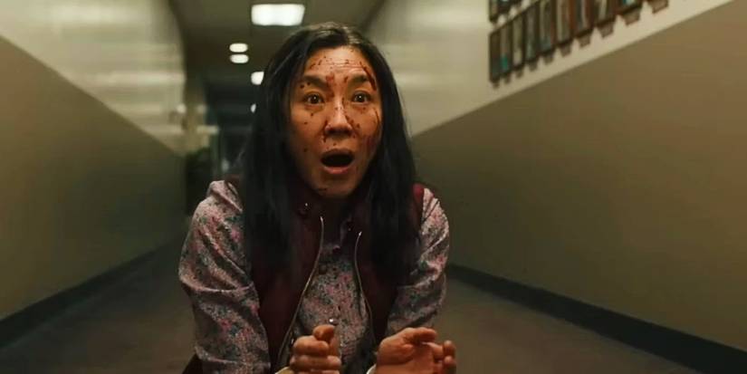 Evelyn Wang (Michelle Yeoh) looks shocked while her face is covered with blood in Everything Everywhere All at Once