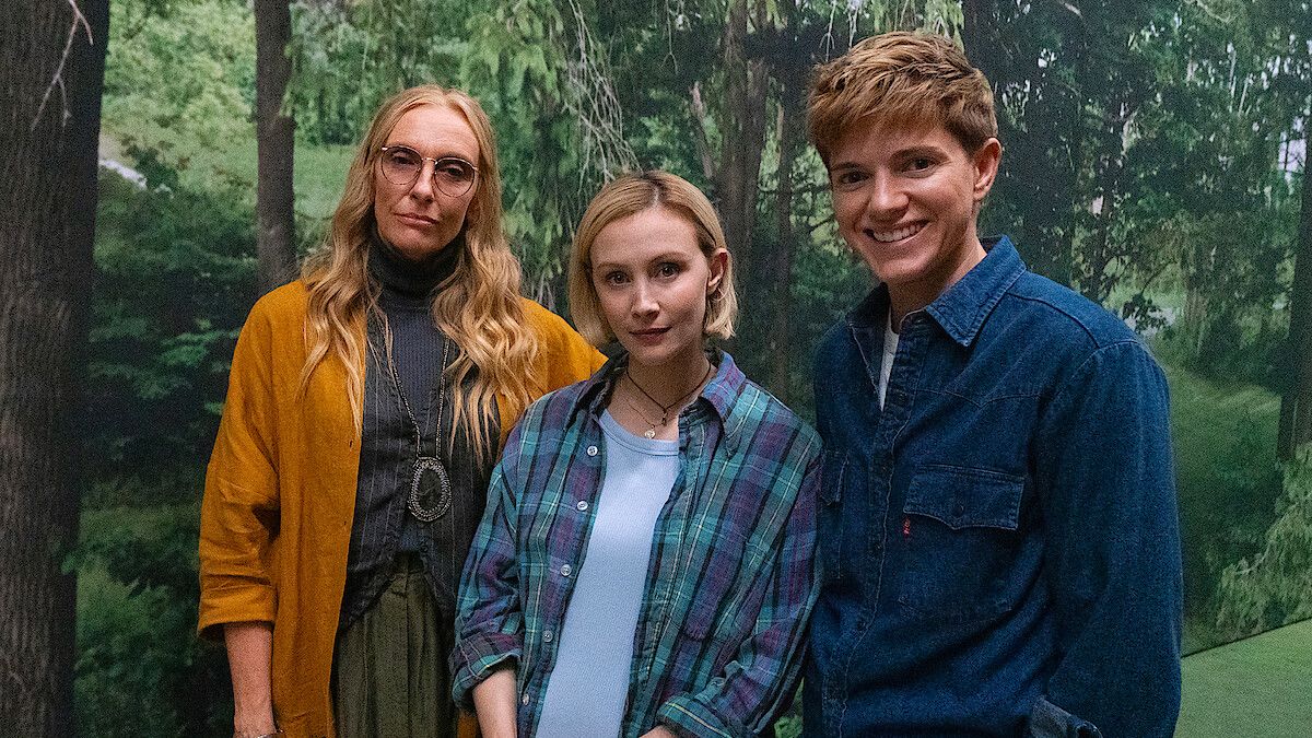 Netflix Wayward com Toni Collette e seus colegas de elenco posando em frente a uma imagem de uma floresta 