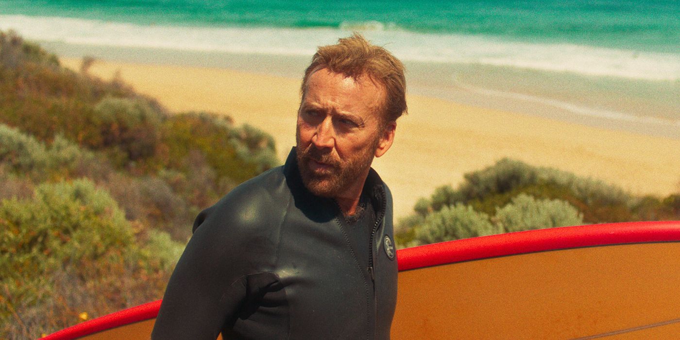 Nicolas Cage holding a surfboard in The Surfer (2025)