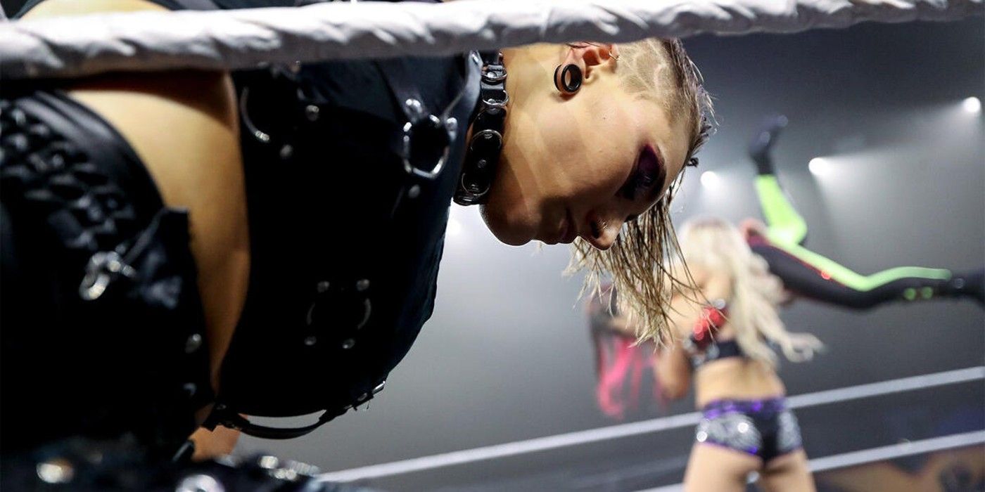 Rhea Ripley em primeiro plano enquanto o corpo de Charlotte Flair bate em Io Shirai no fundo do WWE NXT In Your House