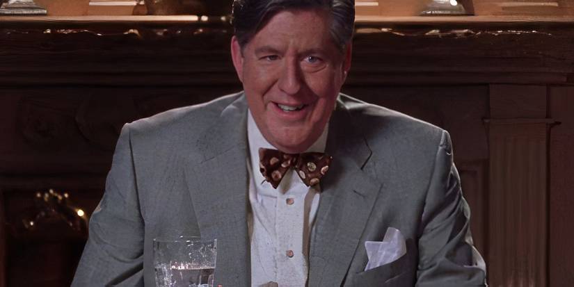 Richard (Edward Herrmann) wearing a grey suit and smiling on Gilmore Girls