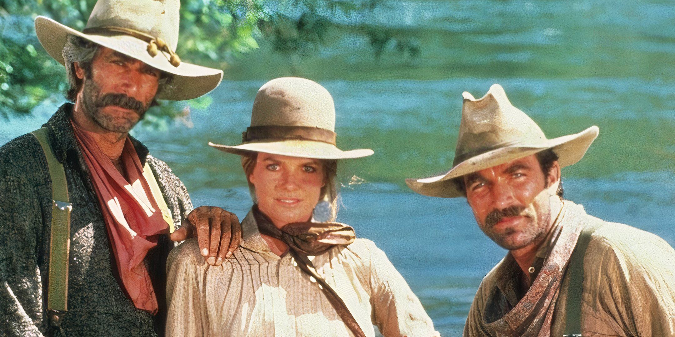 Posing with one another, Sam Elliott places his hand on Katharine Ross' shoulder and Tom Selleck stands next to them.