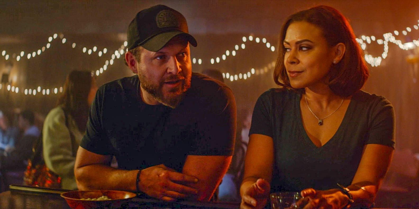 Sonny Quinn (AJ Buckley) y Lisa Davis (Tony Trucks) hablan en un bar en SEAL Team Temporada 7 Episodio 1