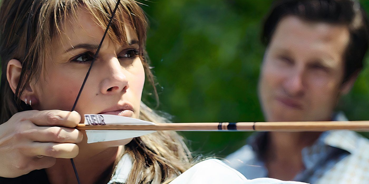 Sophie (Missy Peregrym) nocks a practice arrow while Nolan (Damon Runyan) watches in Out Come the Wolves