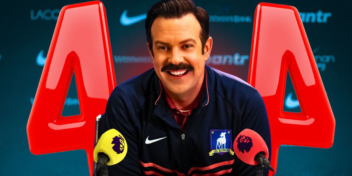 Ted Lasso (Jason Sudeikis) smiling while sitting in front of microphones and with the number 4 in red behind him
