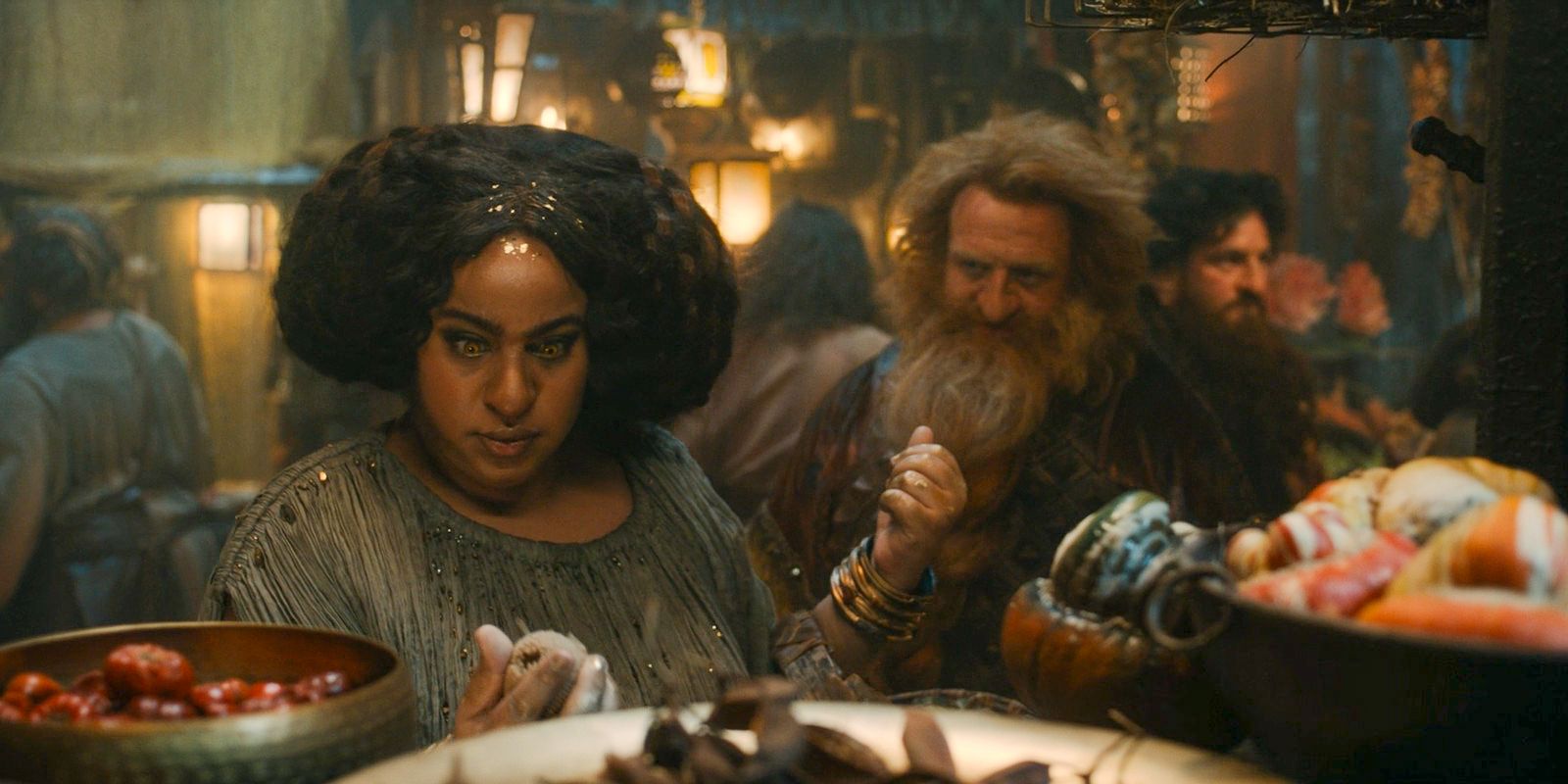 Disa (Sophia Nomvete) and Prince Durin IV (Owain Arthur) shopping at the market in The Lord of the Rings: The Rings of Power Season 2 Episode 2