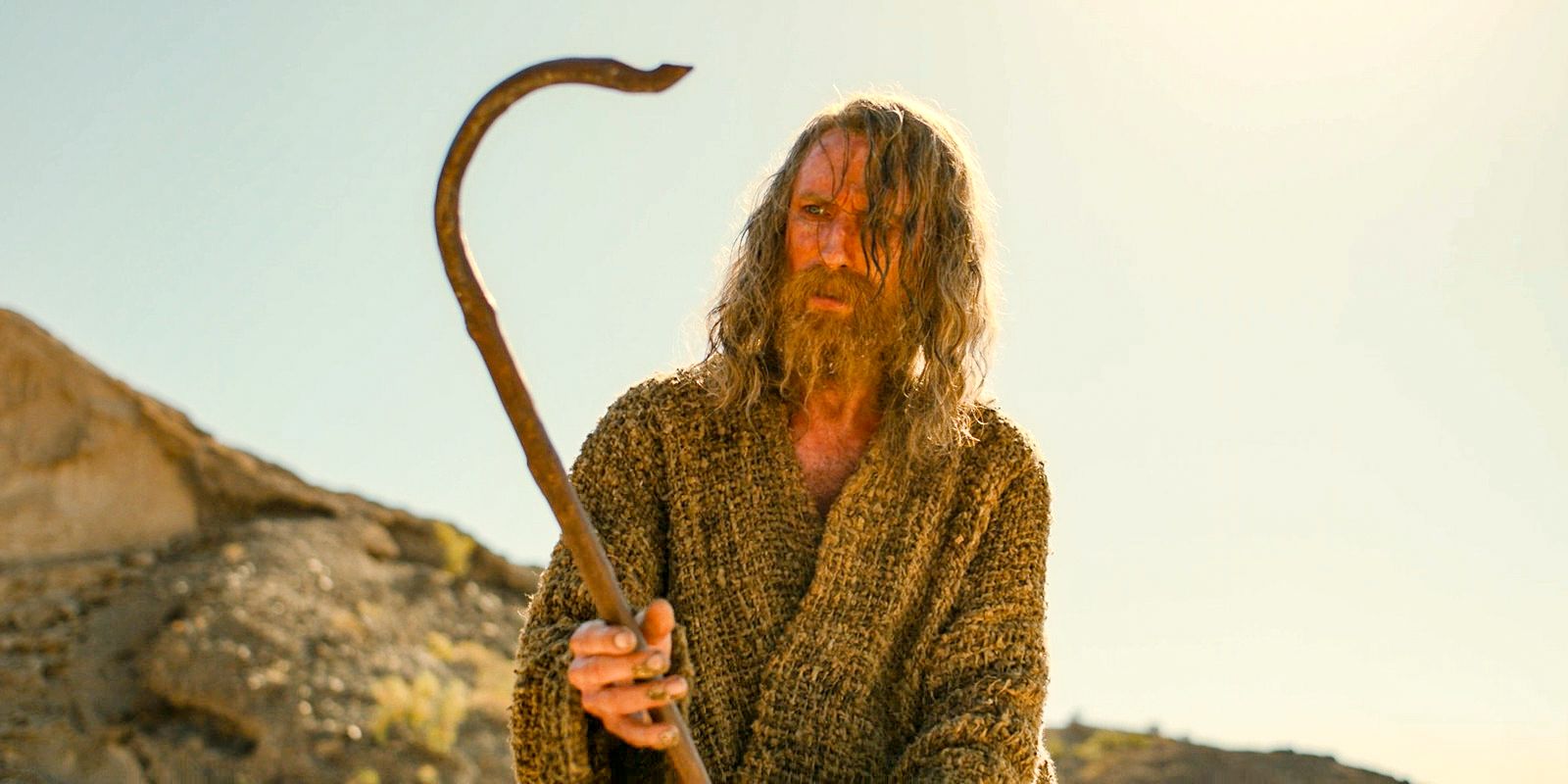 The Stranger (Daniel Weyman) holding the staff he sees in his dreams in The Lord of the Rings: The Rings of Power Season 2 Episode 2