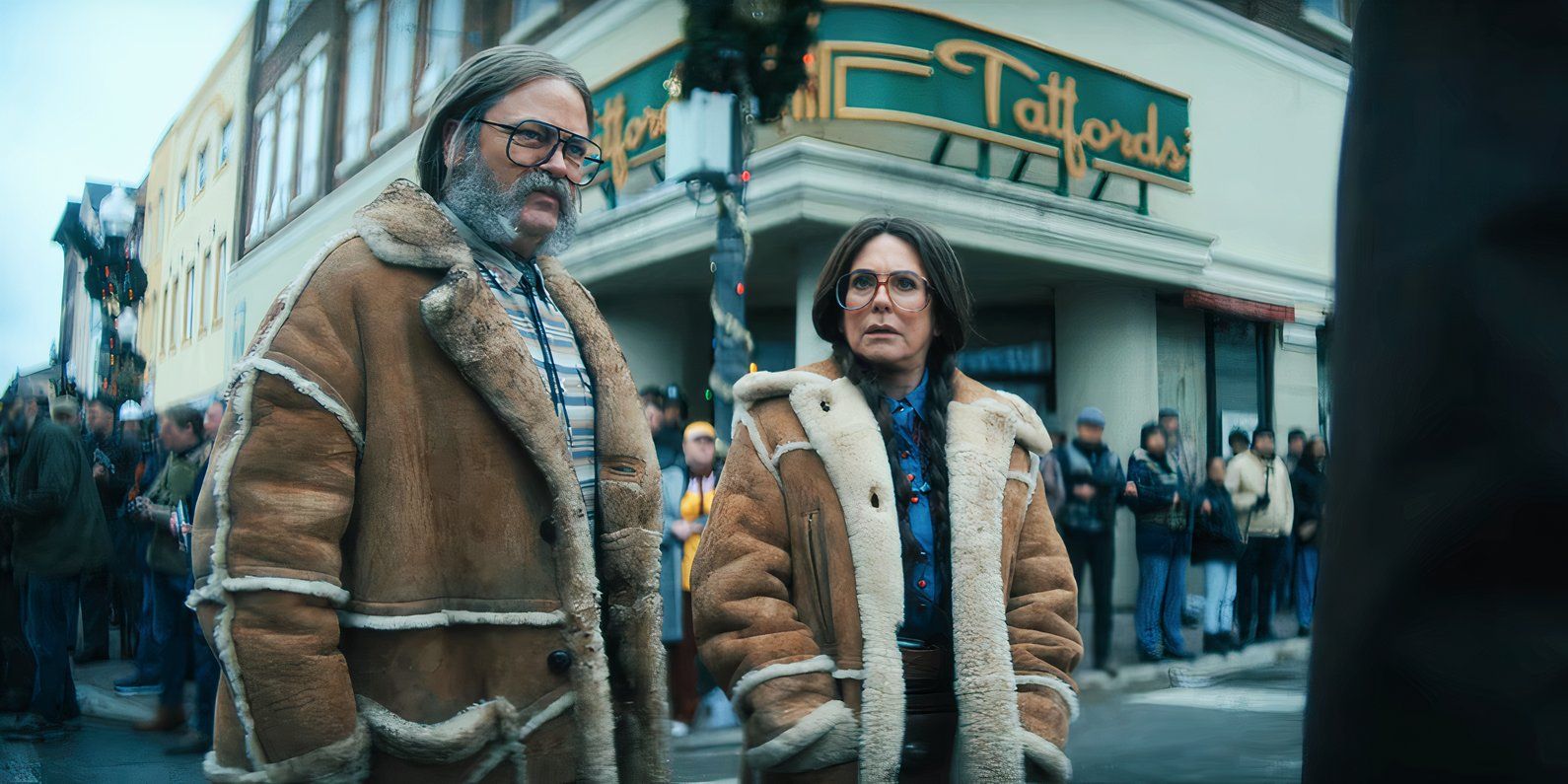 Nick Offerman as Gene standing with Megan Mullally as Jean outside a store in The Umbrella Academy.