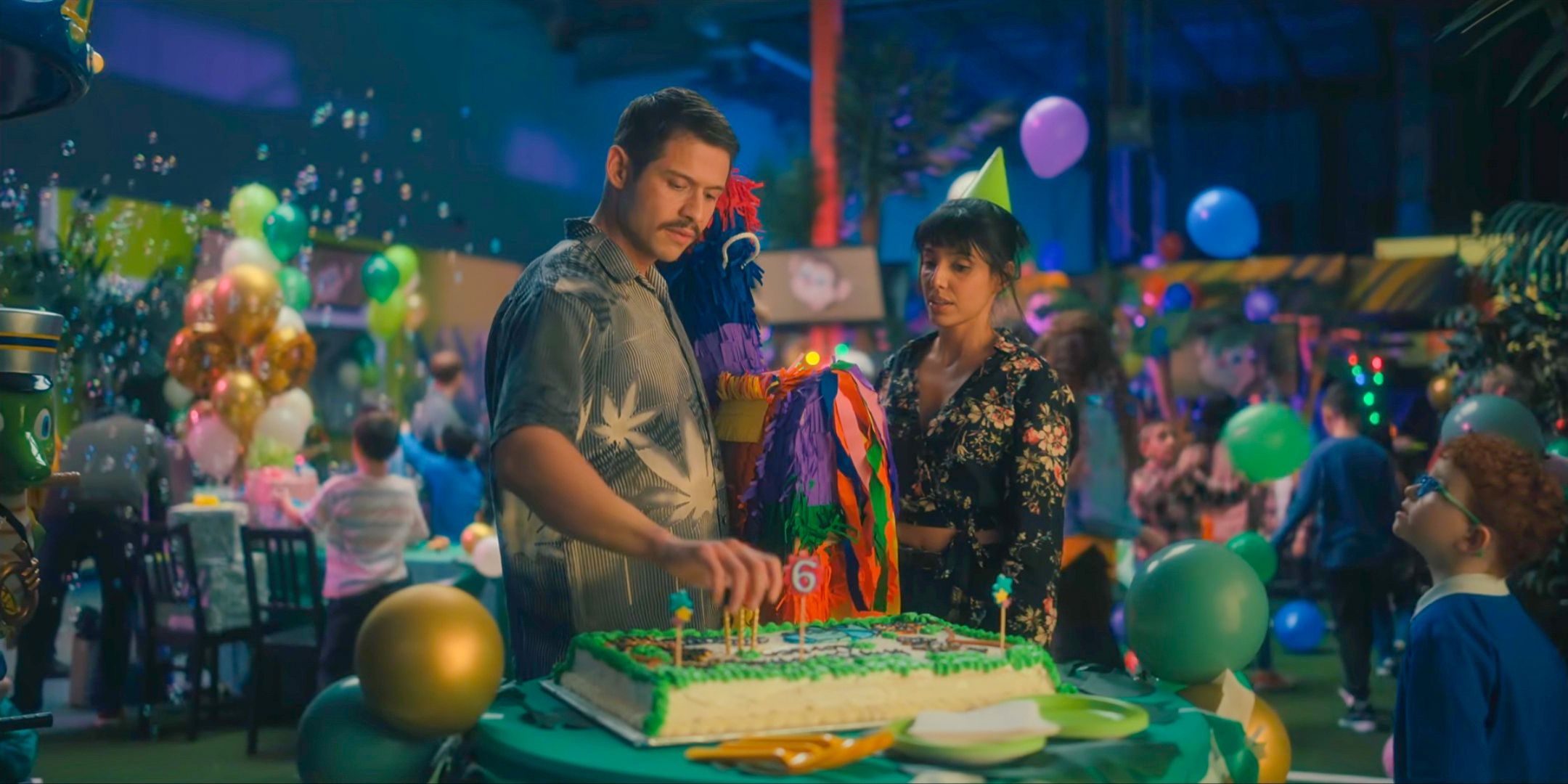 Diego (David Castañeda) and Lila (Ritu Arya) looking annoyed at their daughter's birthday party Klaus