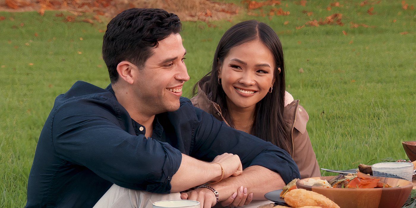 The Bachelorette Jenn Tran smiles at Devin Shrader while they sitting arm in arm in the grass with food in front of them