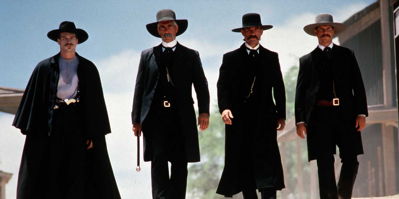 Iconic still from the movie Tombstone featuring Val Kilmer, Bill Paxton, Sam Elliott, and Kurt Russell as the Earps and Doc Holliday.