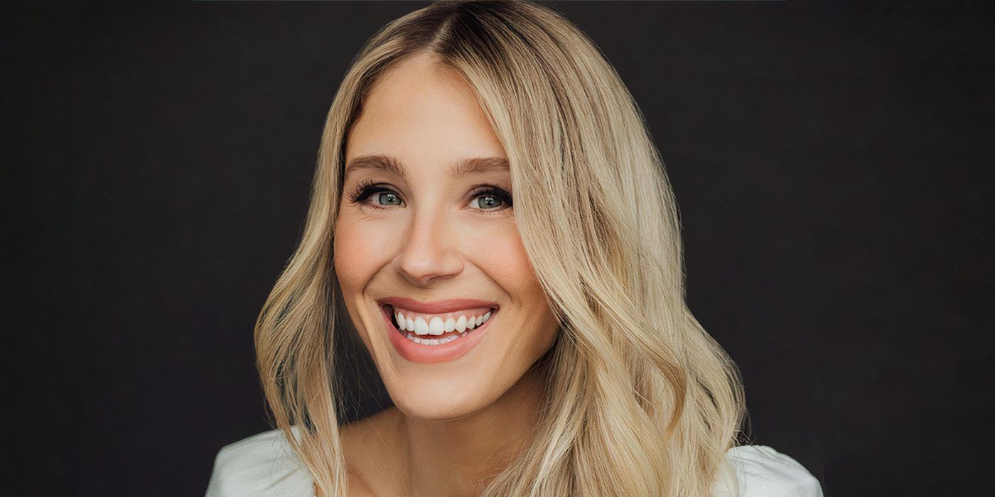 Lisa Gilroy smiles in a headshot against a black backdrop