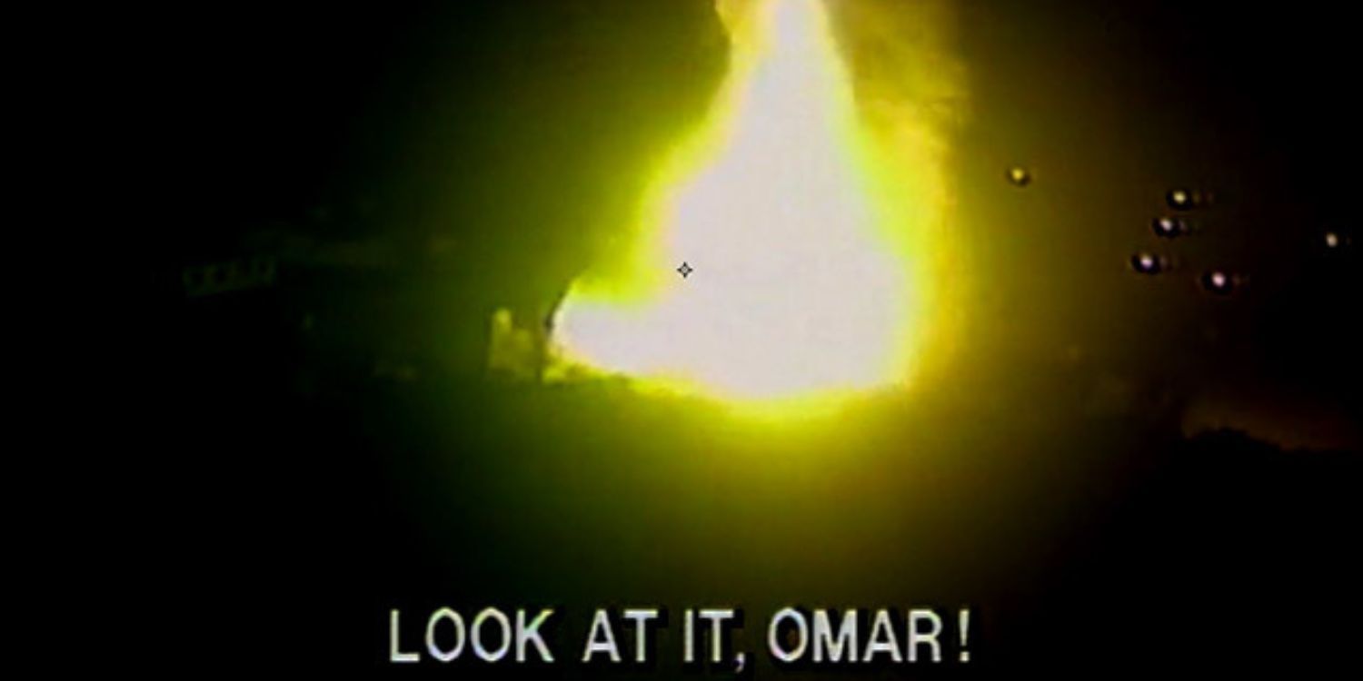 A still from Unsolved Mysteries. Footage of a house fire is shown with the subtitles, "Look at it, Omar!"