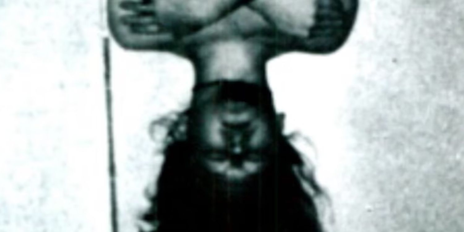 A still from Unsolved Mysteries. A monochrome photo of a boy hanging upside down with his arms crossed on his chest like a bat.