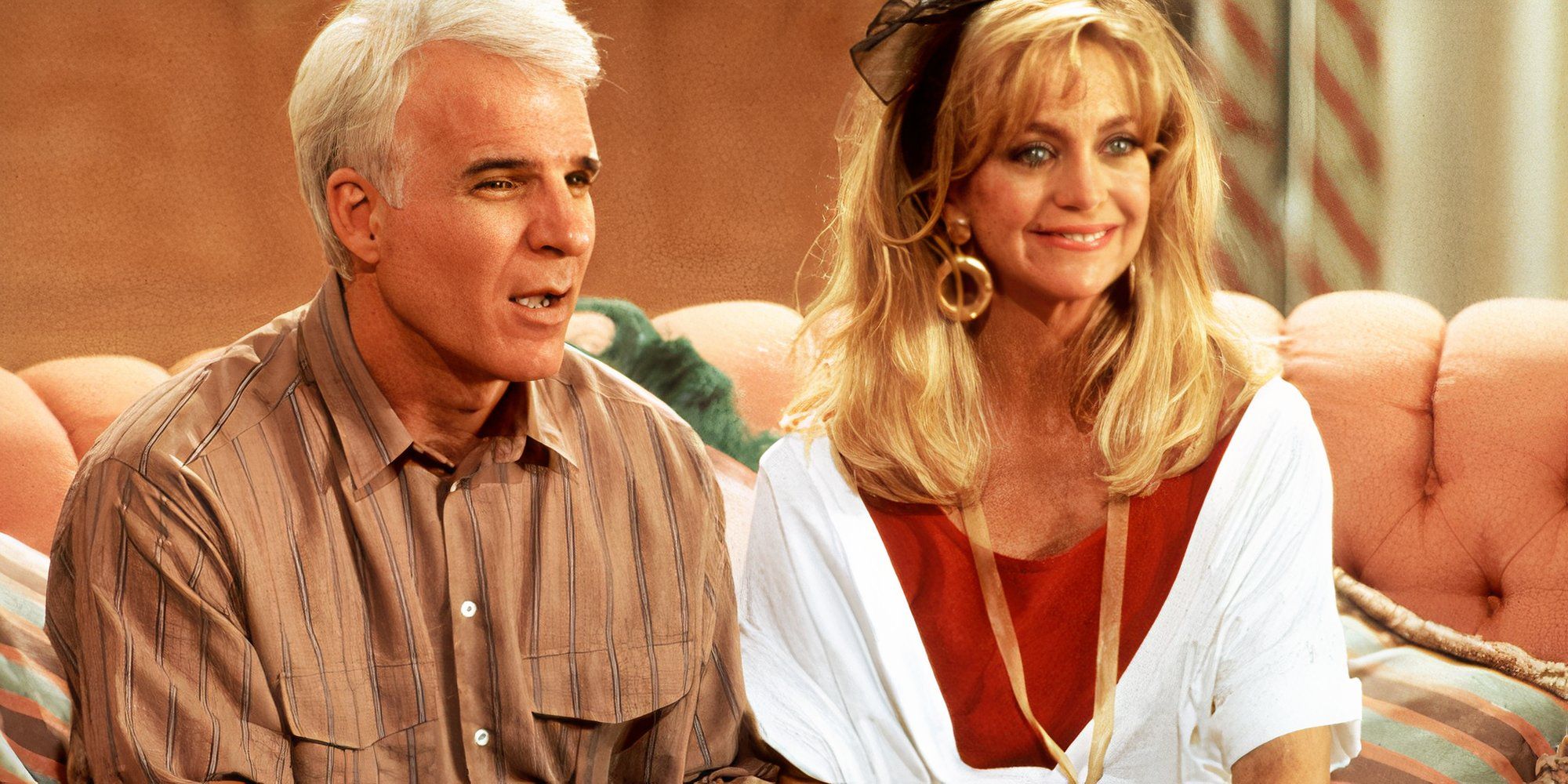 Steve Martin como Newton Davis e Goldie Hawn como Gwen sentaram-se juntos em um sofá em Housesitter.