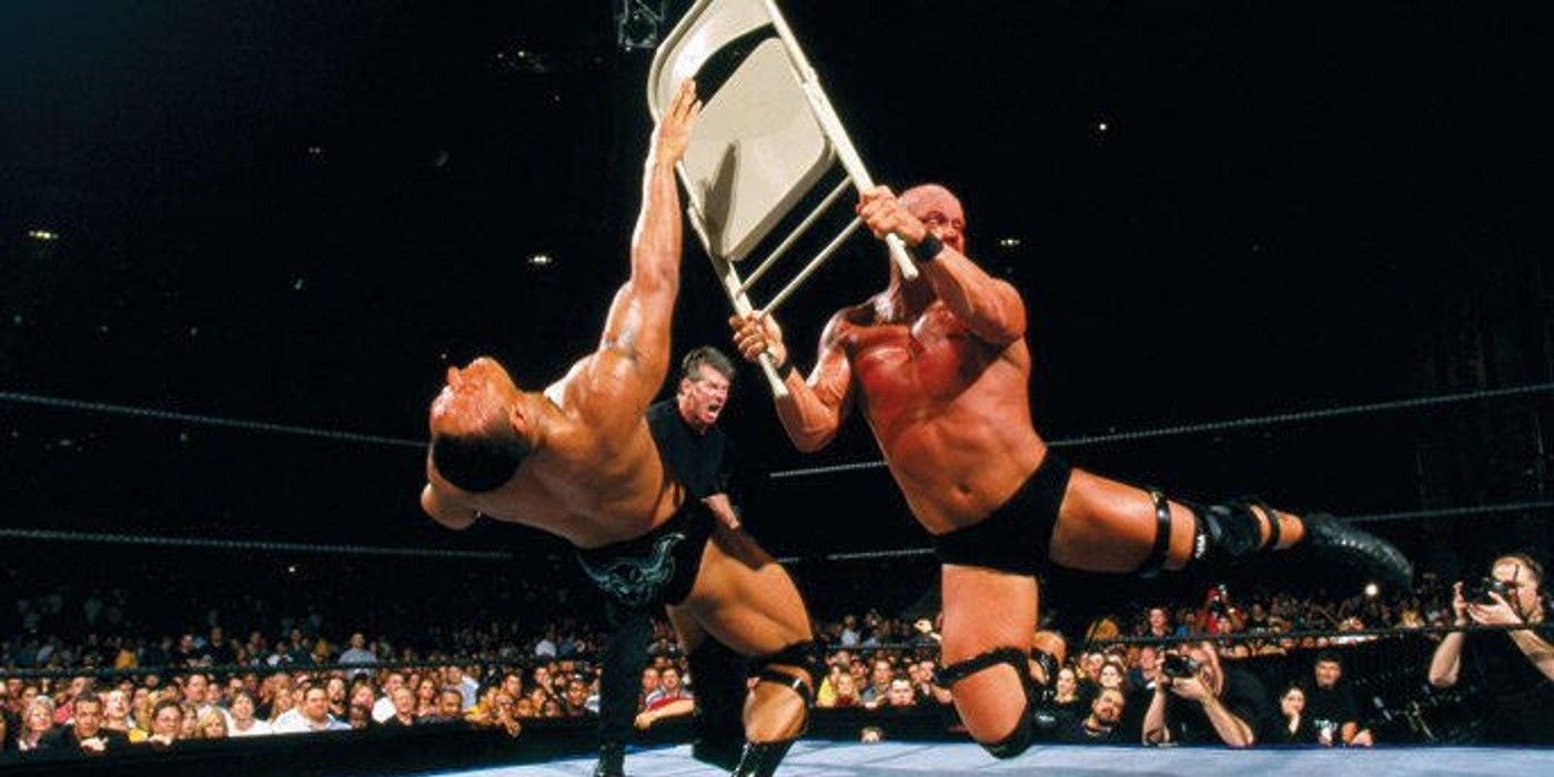 Vince McMahon aplaude Stone Cold Steve Austin enquanto ele atinge The Rock com uma cadeira de aço na WWE WrestleMania X-Seven