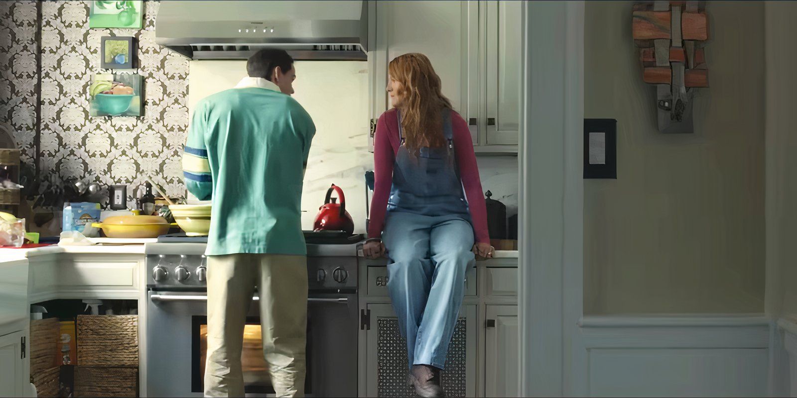 O jovem Atlas cozinha e a jovem Lily senta-se no balcão em It Ends With Us