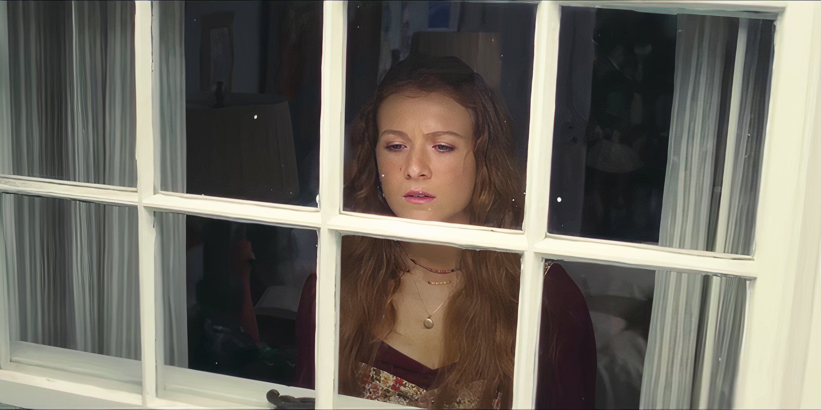 Young Lily looks out her window in It Ends With Us