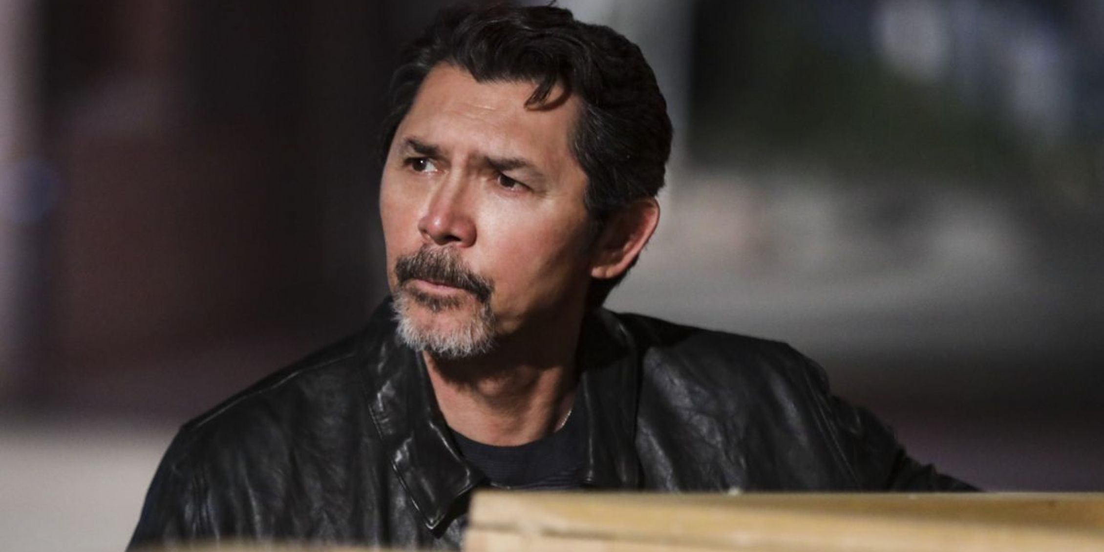 Blue Bloods Luis Delgado sitting by a table