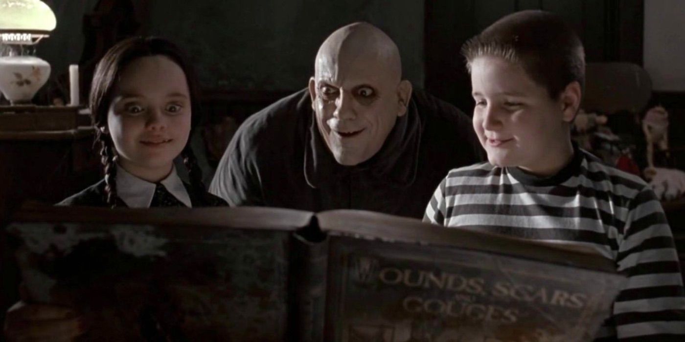 Fester mira un libro antiguo con Wednesday y Pugsley en The Addams Family