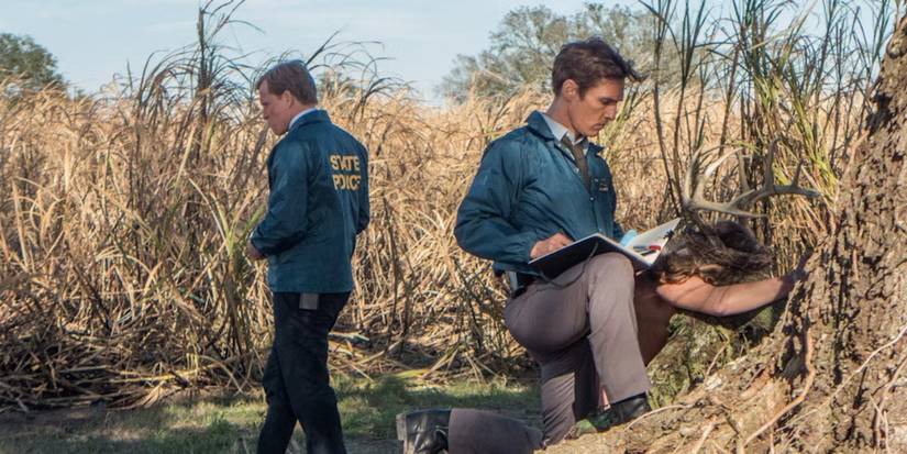 Rust and his partner are examining the crime scene in True Detective Season 1, Episode 1